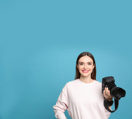 Fototapeta premium Professional photographer with modern camera on light blue background. Space for text