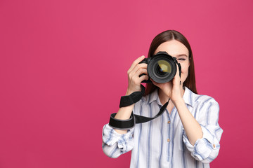 Professional photographer taking picture on pink background