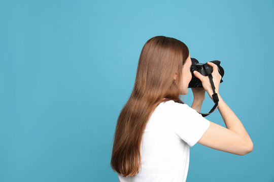 Professional photographer taking picture on light blue background