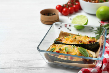 Baked stuffed zucchini on white wooden table. Space for text