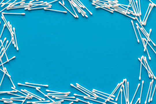 pattern of cosmetic cotton swabs frame on blue background top view mock-up