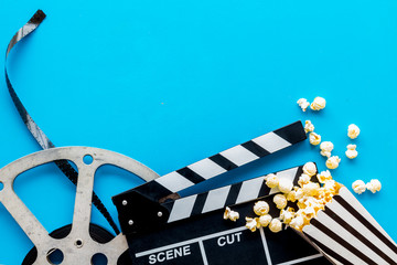 Movie premiere concept with clapperboard, film type, popcorn on blue background top view space for...
