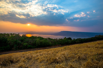 Obraz premium Natural panoramic wallpaper of high mountain scenery, overlooking the atmosphere of rivers, grasslands, roads, and the orange sunshine in the evening, blown through blurred cool air.