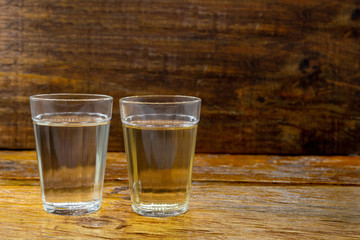 glasses of brazilian cachaça isolated on rustic wooden background. It is used in the preparation of the worldwide known cocktail caipirinha. traditional drink from brazil