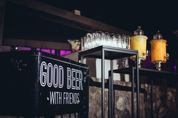 Drinks bar with a mobile black cooler that says "Good beer - with friends". Event design.
