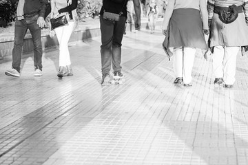 People walking down the street in the afternoon, beautiful sunlight . People walking and boy with skatebord listening to music. background black and white - Image