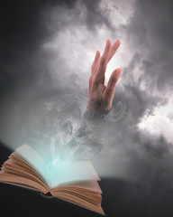 Mano fant&aacute;stica saliendo sobre m&aacute;gico libro