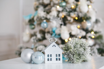 Decorative New Year composition with symbolical house and beautiful lights bokeh. Christmas eve