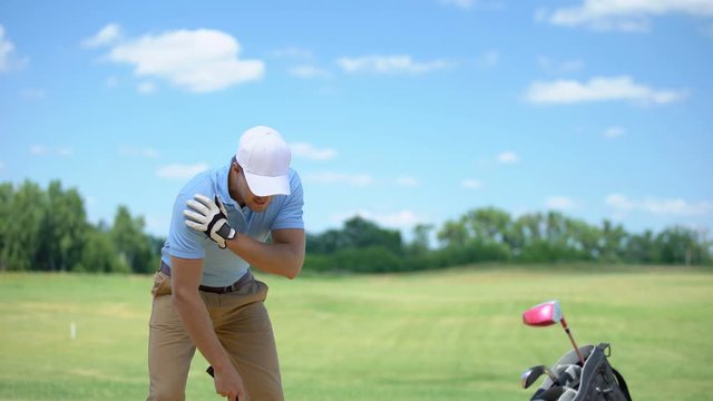 Experienced golfer hitting ball, suddenly feeling shoulder pain, inflammation