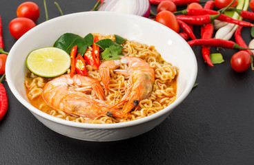 Instant noodles, Tom Yum Kung flavor Spicy, spicy flavor with Thailand spices placed on the table, black background.