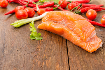 Raw salmon fillets and ingredients for cooking on old wooden floors