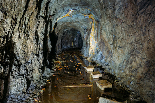 Dark creepy dirty flooded abandoned mine tunnel