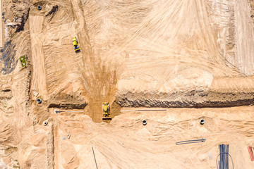 yellow bulldozer working at construction site. aerial top view