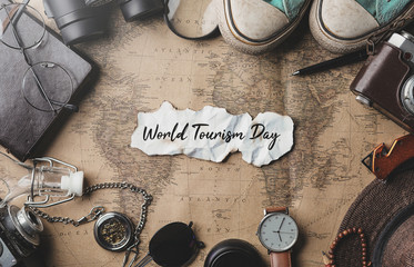 World Tourism Day. Travel Concept Background. Overhead View of Traveler's Accessories on Old Vintage Map