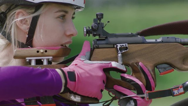Portrait of Caucasian female professional biathlete practicing on a shooting range during mid-season practice in summer. ARRI Alexa Mini with Cooke S4 prime lenses RAW graded footage