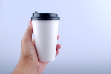 Male hand holding a Coffee paper cup isolated on white background.