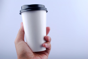 Male hand holding a Coffee paper cup isolated on white background.