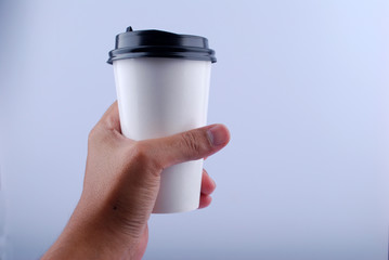Male hand holding a Coffee paper cup isolated on white background.