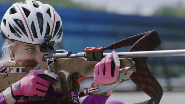 Portrait of Caucasian female professional biathlete practicing on a shooting range during mid-season practice in summer. ARRI Alexa Mini with Cooke S4 prime lenses RAW graded footage