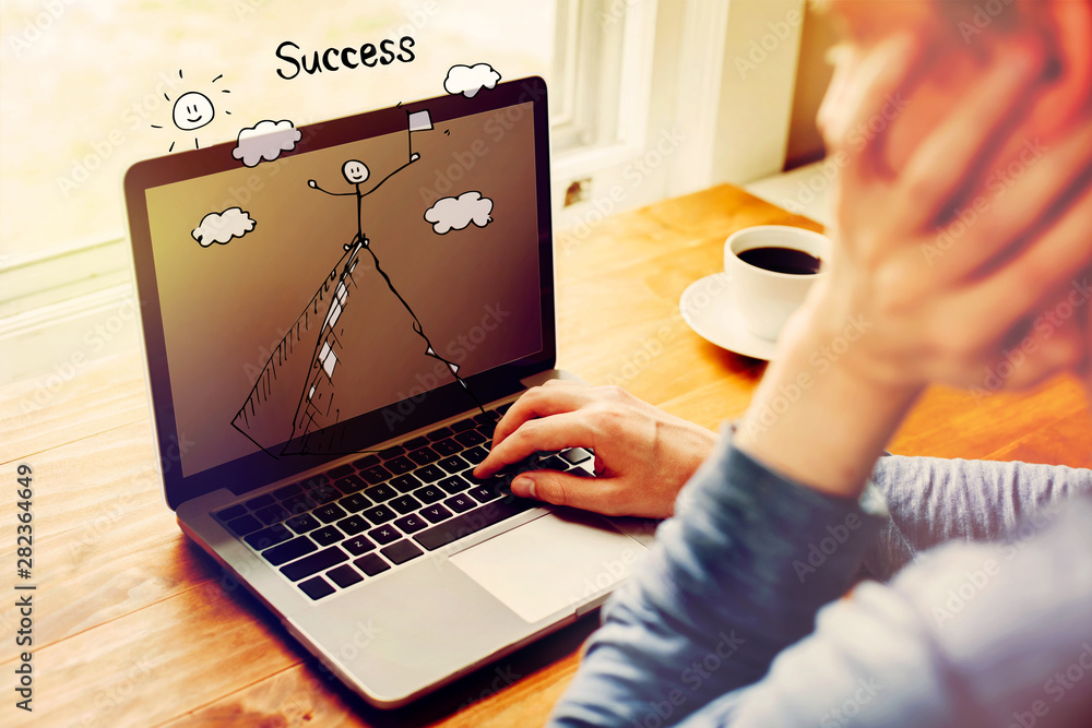 Poster standing on the top of a mountain with man using a laptop computer