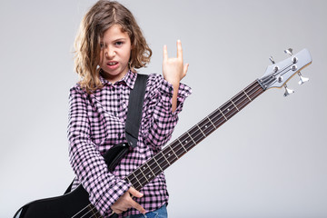 Fototapeta premium Girl playing guitar giving a Devil Horns sign