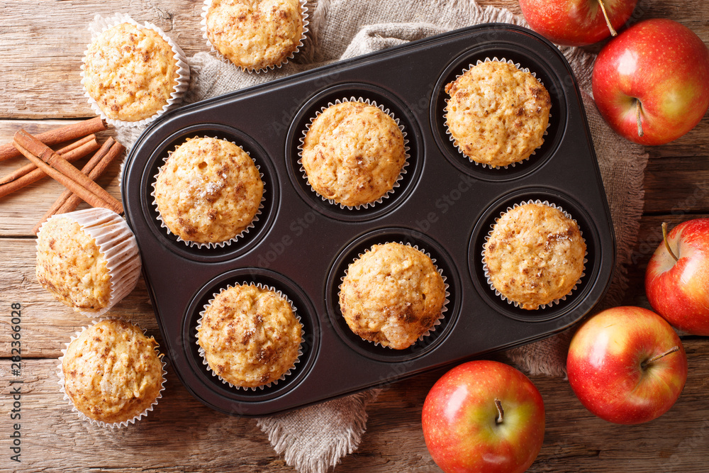 Poster Rustic style fresh apple muffins with cinnamon close-up on the table. Horizontal top view