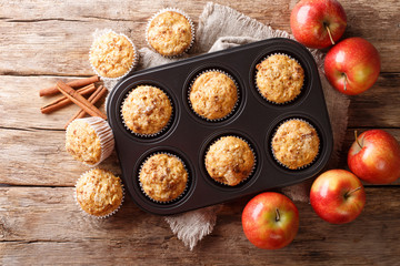 Tasty baked apple muffins with cinnamon close-up in a tray. Horizontal top view