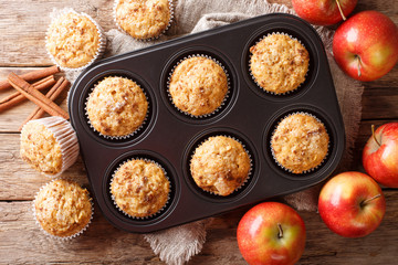 Rustic style fresh apple muffins with cinnamon close-up on the table. Horizontal top view