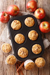 Rustic style fresh apple muffins with cinnamon close-up on the table. Vertical top view