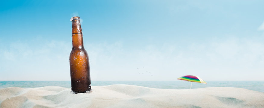 beer bottle on the beach in summer with blue sky