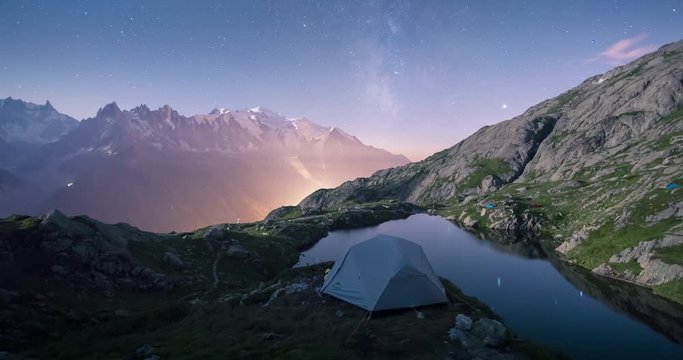 Night timelapse  from lake des Cheserys, Chamonix. Mont blanc and milky way as background elements. Camping tent as main subject in the foreground. Moon rising during the night.