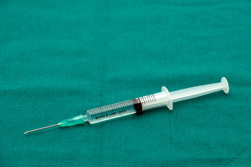 Liquid parenteral products in syringe isolated on surgical green drape fabric