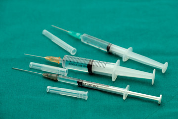 Liquid parenteral products in syringe isolated on surgical green drape fabric