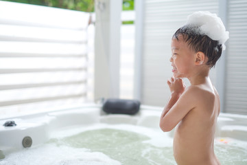 Smiling little Asian 3 - 4 years old toddler boy child take a shower by himself, Kid wash hair with shampoo, Encourage Self-Help Skills in Children, The growth of independence in young child concept - obrazy, fototapety, plakaty