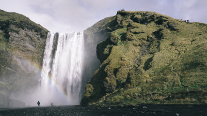 Rainbow appearing in front of Skógafoss waterfall in Iceland