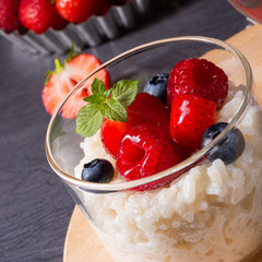 delicious milk rice with different berries and red fruit jelly