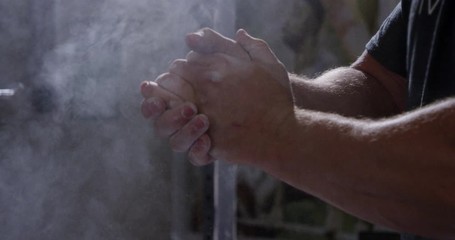 Powerlifters rubbing hands with chalk close up