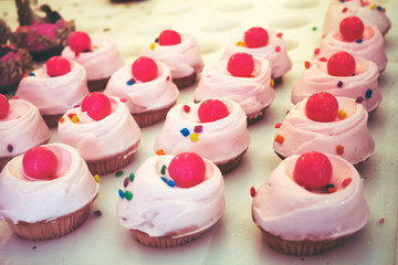 An array of cupcakes on display at a bakery