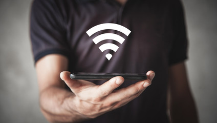 Man holding smartphone with wi-fi sign. Internet, Technology - obrazy, fototapety, plakaty