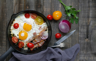 Frying pan with eggs, bacon and tomatoes. Top view, flat lay.