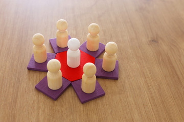 business concept image of tangram puzzle blocks with people figures over wooden table ,human resources and management concept