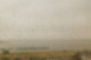 Window view during rain, focus on drops on the glass. Gives a sad autumn mood.