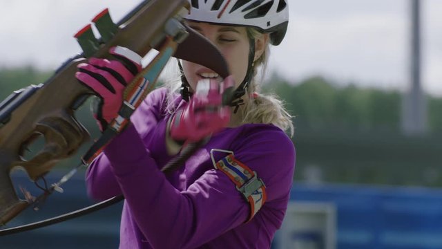 Portrait of Caucasian female professional biathlete practicing on a shooting range during mid-season practice in summer. ARRI Alexa Mini with Cooke S4 prime lenses RAW graded footage