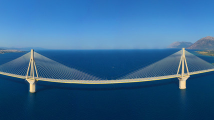 Aerial drone photo of world famous cable suspension bridge of Rio - Antirio Harilaos Trikoupis, crossing Corinthian Gulf, mainland Greece to Peloponnese, Patras