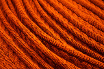 Knitted blanket in autumn colors. Soft and warm fabric. Texture for background or illustrations.