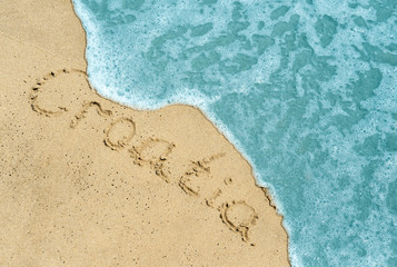 Fototapeta na wymiar Croatia title on the light sand beach near the black sea coast. Croatia lettering or inscription on the sand beach.