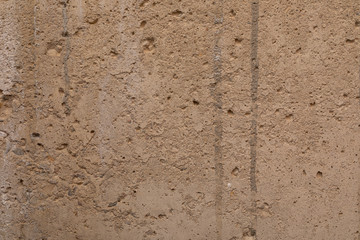 A beige old uneven plastered wall