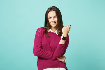 Fototapeta premium Young brunette woman girl in casual clothes posing isolated on blue green turquoise wall background studio portrait. People sincere emotions lifestyle concept. Mock up copy space. smart watch on hand.