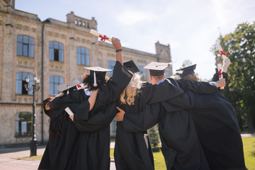 Group of graduates saying goodbye to their university.