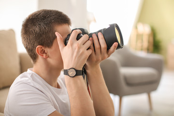 Teenage boy with photo camera at home